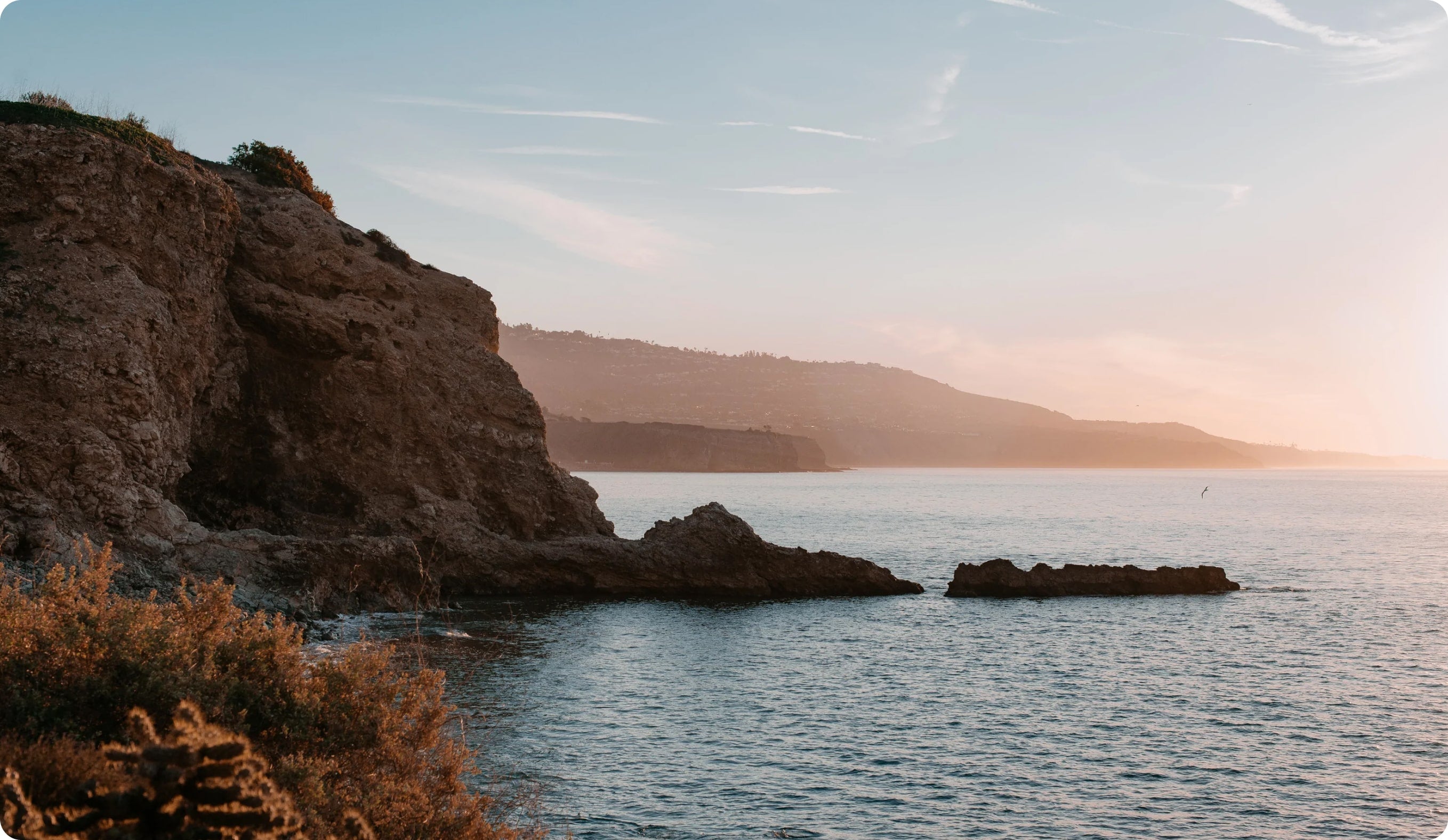 Waves crashing over the cliffs of the beautiful pacific ocean at sunset