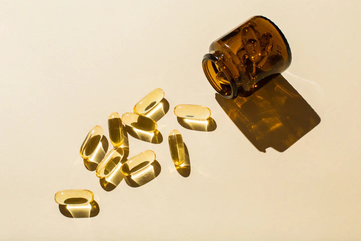 Fish oil capsules spilling out of a jar
