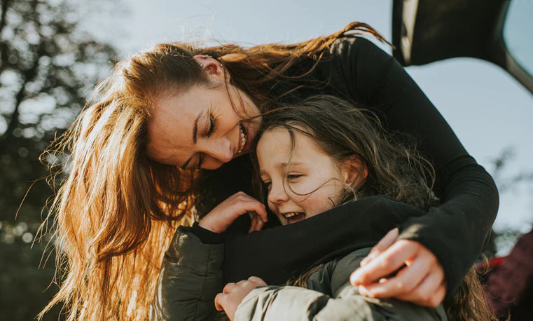 Mom hugging her child laughing