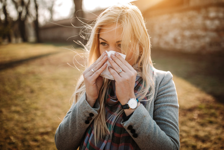 Young woman sneezing from allergies