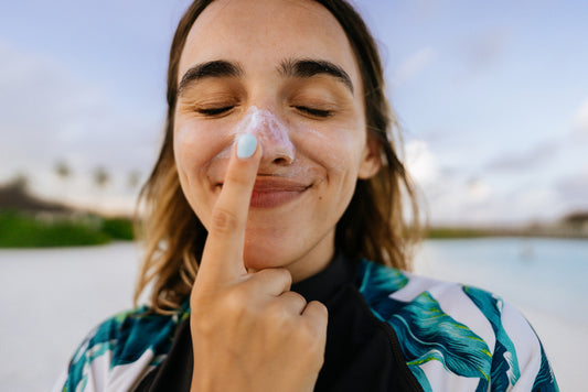 Woman applying zinc sunscreen to nose 