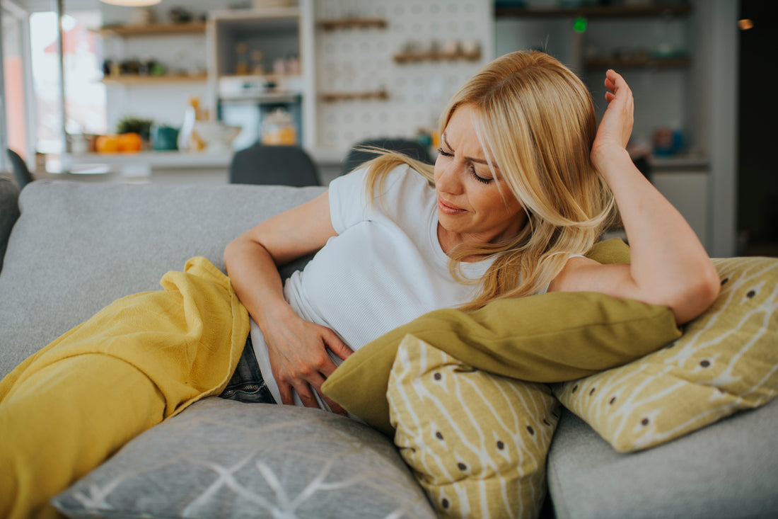 Woman with hands on stomach suffering from pain stock photo