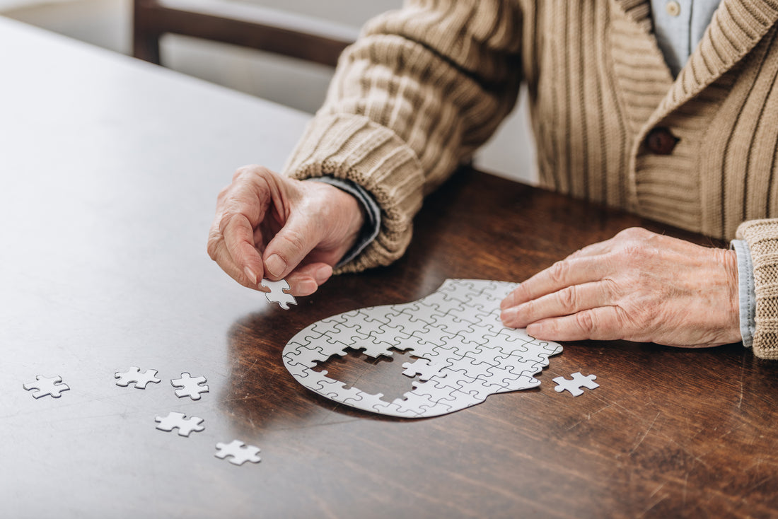 A cropped view of a senior man playing with puzzles.
