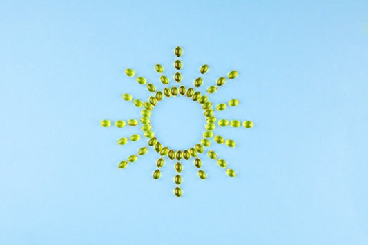  Yellow capsules with Vitamin D3 in the form of the sun with rays. 