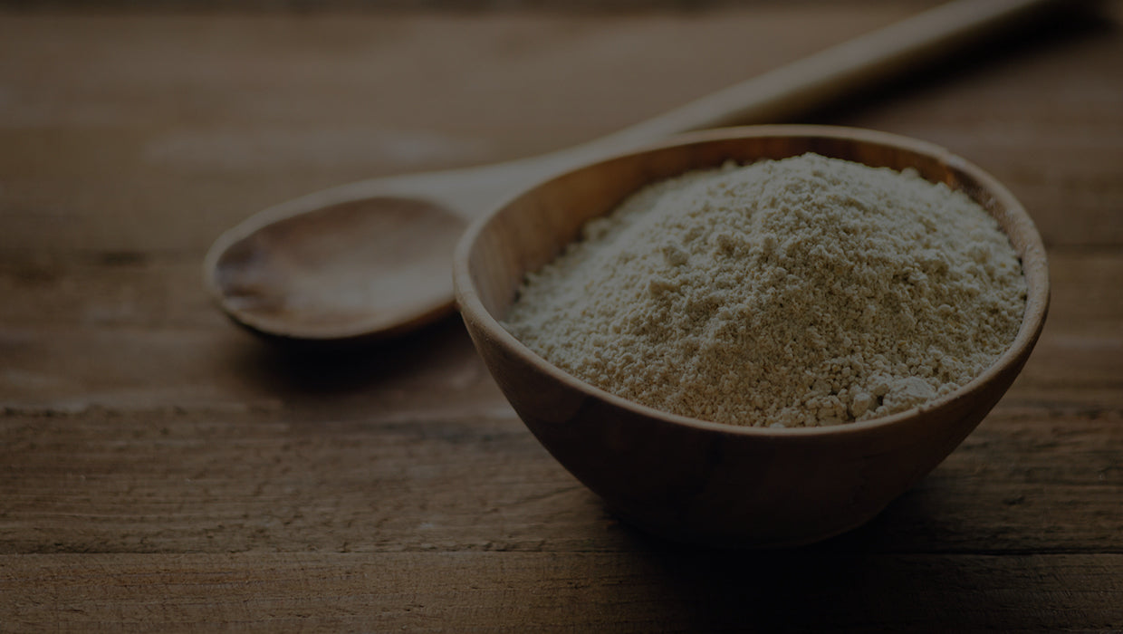 Powdered quercetin in a wooden bowl on a wooden tabletop